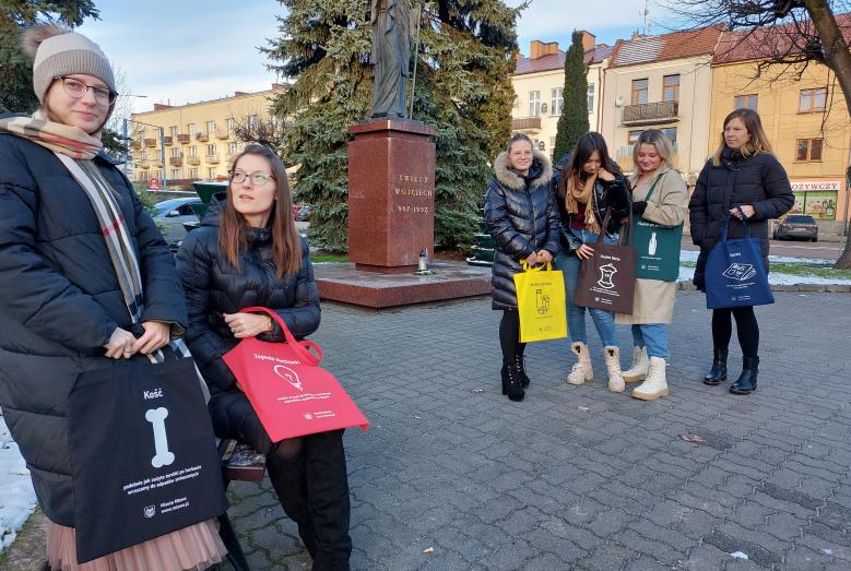 pięć kobiet z torbami, w tle pomnik św. Wojciecha