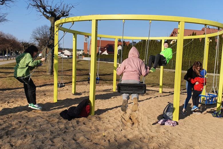 Wieloosobowa huśtawka i korzystające z niej osoby