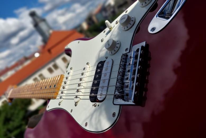 gitara, w tle ratusz w Mławie