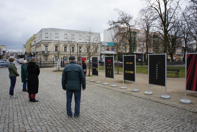 Grupa osób oglądających wystawę w miejskim parku