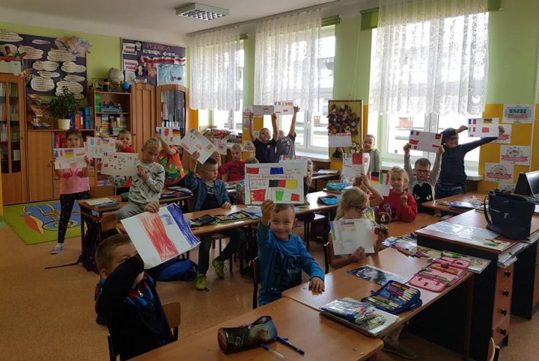 dzieci pokazują kartki z napisami w różnych językach
