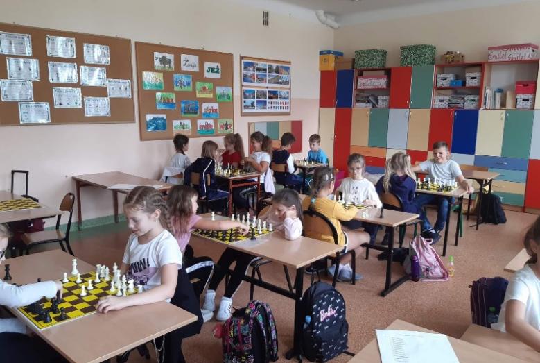 Nowy rok szkolny i nowe  dodatkowe zajęcia w klasie 1b oraz szlifowanie swoich umiejętności szachowych w klasie 3a, gdzie na szachownicy wszystkie figury szachowe i jeden cel danie mata, tzn. zagrożenie królowi przeciwnika.   Zaś klasa 1b dzisiejsze zajęcia rozpoczęła wierszykiem- Pion to żołnierz szeregowy,  Bronić króla wciąż gotowy,  Chodzi prosto, bije skosem  I nie cofa się przed ciosem. A następnie  rozegrała pierwszy sparing!  Wygrał ten, kto pierwszy doprowadził  piona do ostatniej linii (za linie p