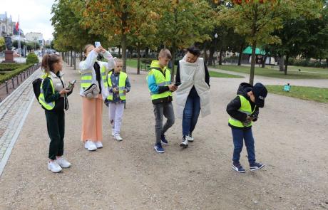 dzieci z opiekunką podczas spaceru w parku