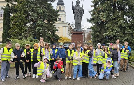 uczniowie i nauczycielki Szkoły Podstawowej nr 2 w Mławie przed pomnikiem św. Wojciecha