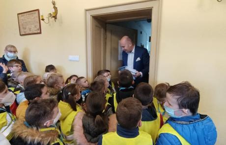 Burmistrz Sławomir Kowalewski wręcza dzieciom mławskie kolorowanki