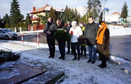 Siedem osób składających kwiaty i znicze