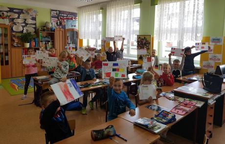 dzieci pokazują kartki z napisami w różnych językach