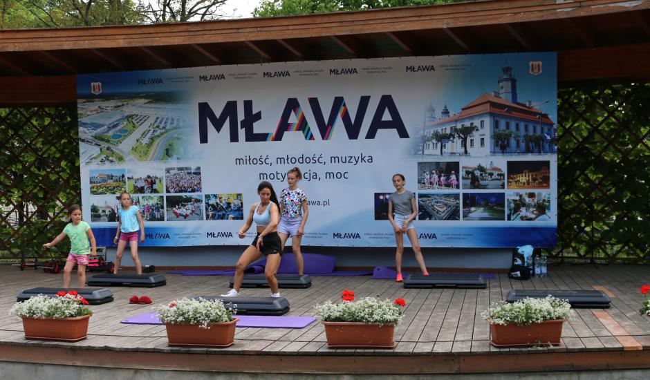 Ćwiczenia aerobiku na scenie w parku w Mławie