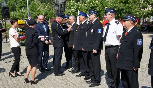 Sławomir Kowalewski i Leszek Ośliźlok dekorują strażaków medalami Zasłużony dla Miasta Mława