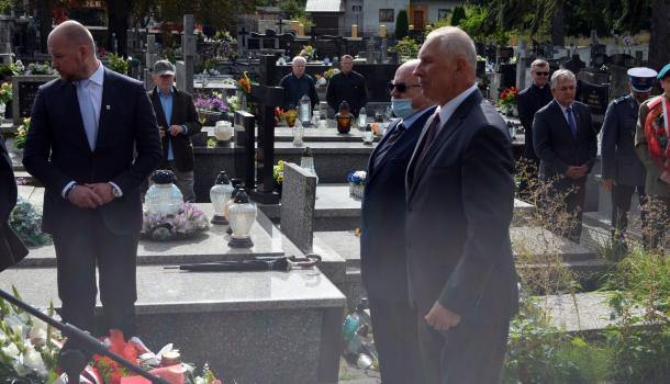 Uczestnicy uroczystości składają kwiaty i zapalone znicze