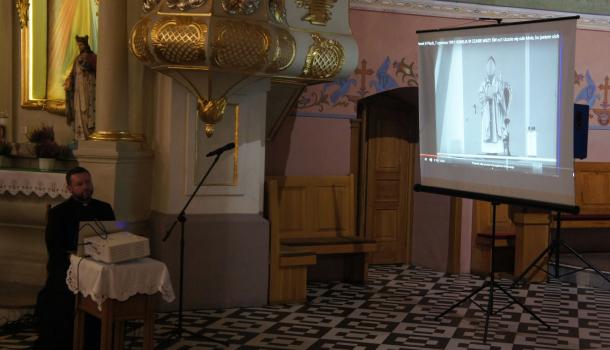 ks. Marcin Sadowski przed ekranem projekcyjnym
