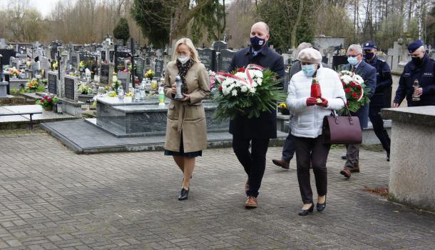 Składanie kwiatów i zniczy pod pomnikiem na cmentarzu parafialnym