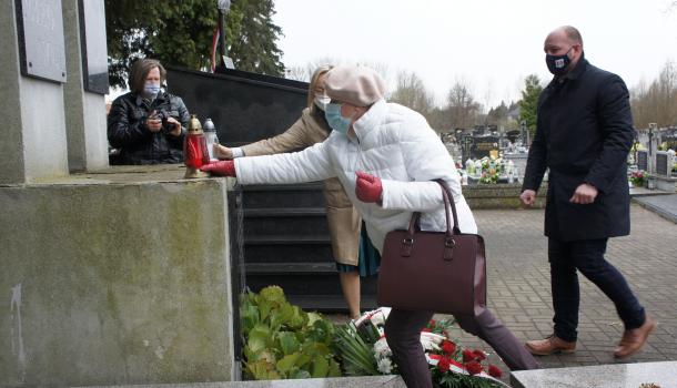 Składanie kwiatów i zniczy pod pomnikiem na cmentarzu parafialnym