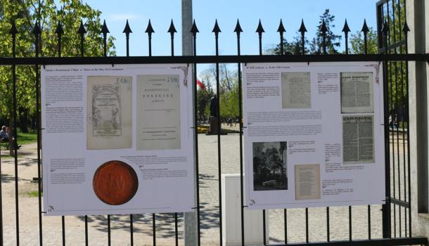 Dwie plansze wystawy na ogrodzeniu parku