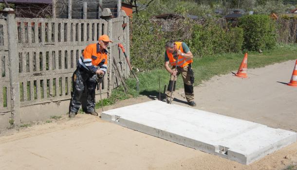 Dwaj mężczyźni kładący płytę betonową