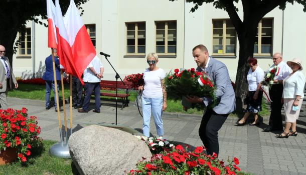 Składanie kwiatów pod głazem z tablicą poświęconą wyzwolicielom Mławy z 1920 roku