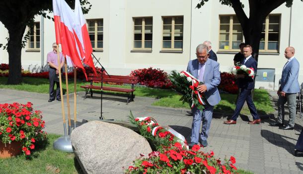 Składanie kwiatów pod głazem z tablicą poświęconą wyzwolicielom Mławy z 1920 roku