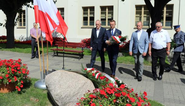Składanie kwiatów pod głazem z tablicą poświęconą wyzwolicielom Mławy z 1920 roku