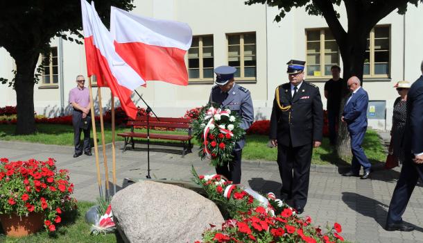 Składanie kwiatów pod głazem z tablicą poświęconą wyzwolicielom Mławy z 1920 roku