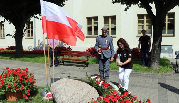 Składanie zniczy pod głazem z tablicą poświęconą wyzwolicielom Mławy z 1920 roku