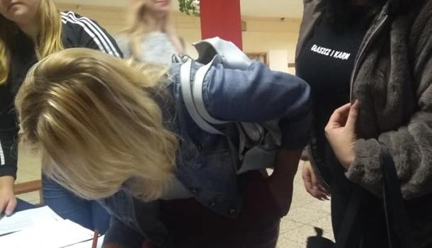 Wyborca odbiera kartę do głosowania 
