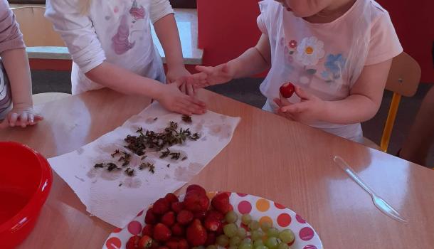 dzieci kroją owoce na sałatkę 