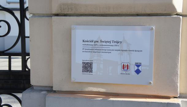 tabliczka na ogrodzeniu kościoła pw. Świętej Trójcy